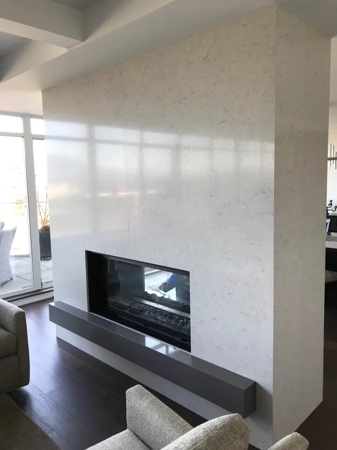 Linear fireplace set within a pale full-height surround.