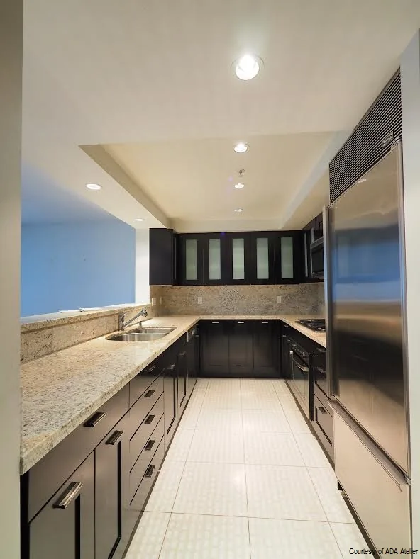 Galley kitchen with dark lower cabinetry and light work surfaces.